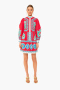 A woman faces forward in a bright red La DoubleJ dress with blue and white floral embroidery, long sleeves, and beige heeled sandals¡ªa Milan-inspired look featuring signature archival prints.